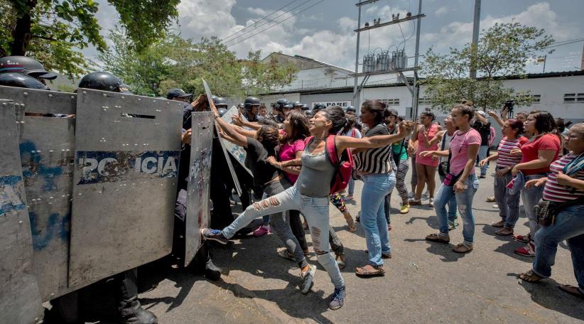 Un grupo de familiares de presos protesta ante miembros de la Policía